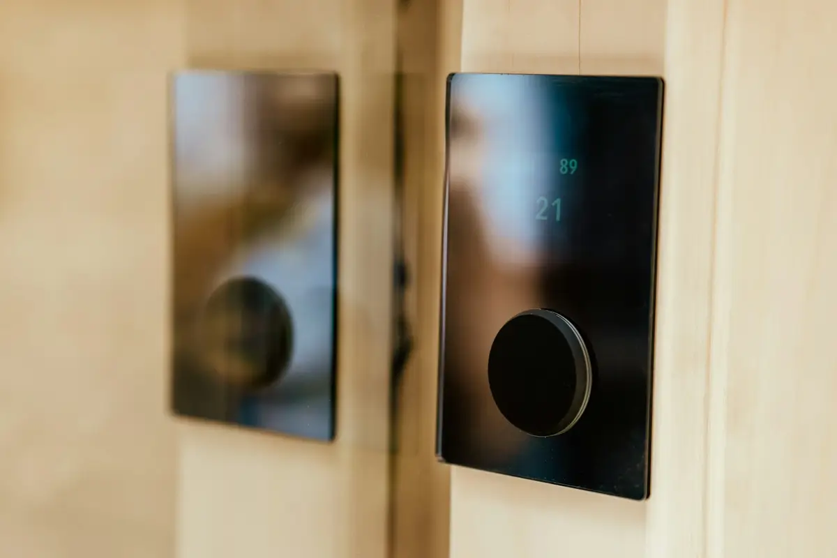 Cerradura inteligente negra con pantalla instalada en una puerta de madera clara
