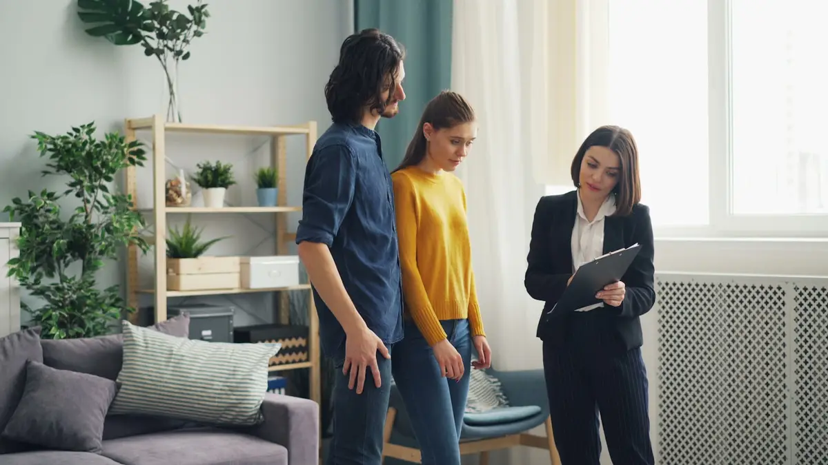 Pareja revisando un presupuesto con una profesional en el salón de su vivienda